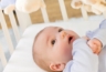 Een baby in de wieg kijken naar zijn/haar verzorger
